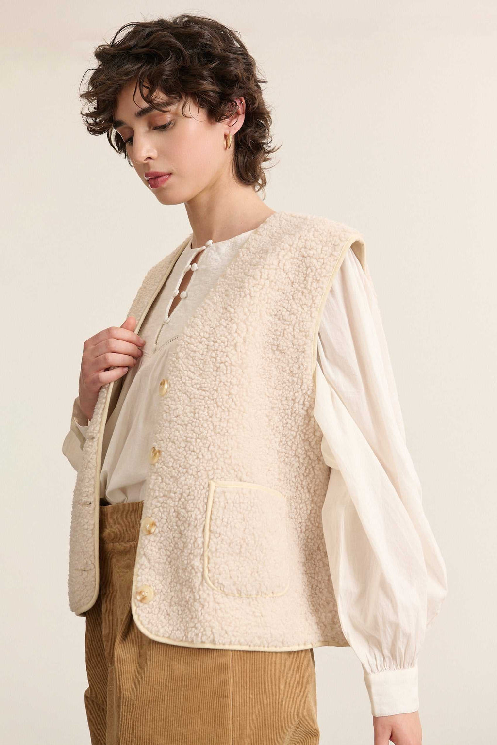 Chaqueta sin mangas con cuello redondo sin exceso de espesor, con discreta costura interior para un look limpio.