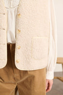 Matière 100 % polyester effet peau de mouton, toucher doux et duveteux avec aspect bouclette sur toute la surface.