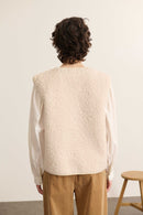 Vue arrière de la veste sans manches, coupe droite avec finitions nettes et encolure arrondie bordée proprement.