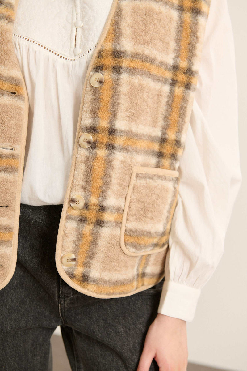 Matière effet peau de mouton 100 % polyester, imprimée jaune avec motif irrégulier sur toute la surface.