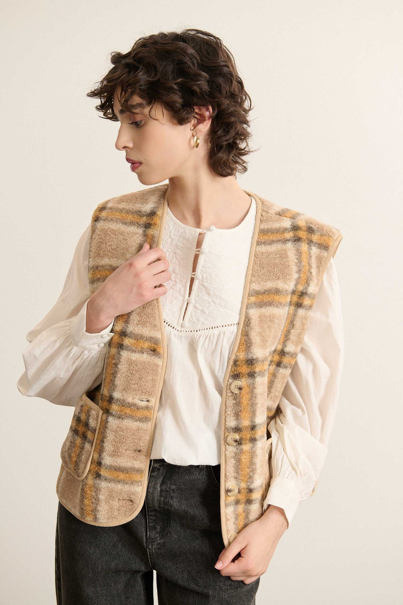 Veste sans manches fabriquée entièrement en polyester coloris jaune avec poches  à l'avant et bouton effet corne.