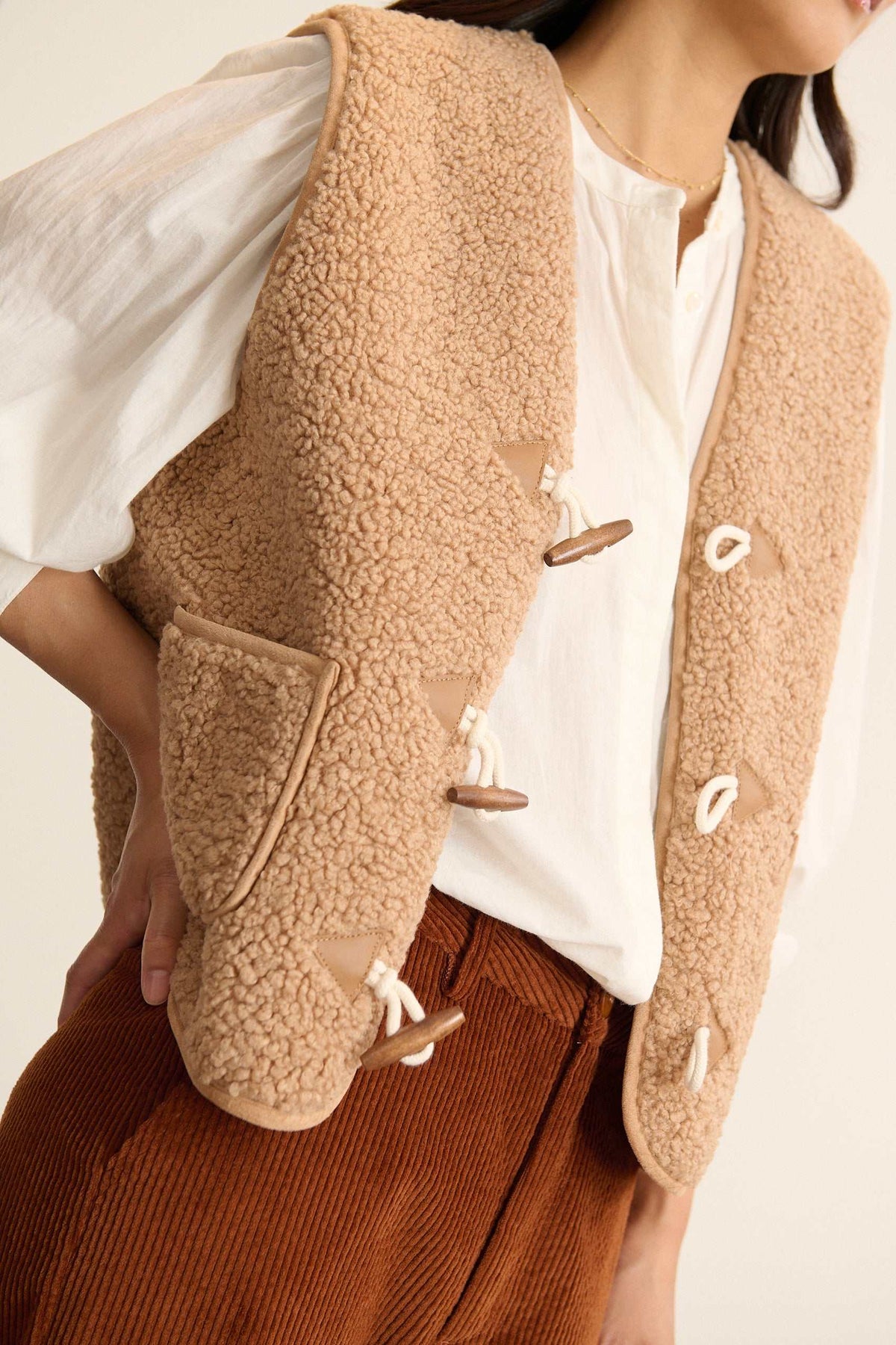 Fermeture par bouton brandebourg contrasté, veste d'hiver sans manches de couleur beige pour femmes.