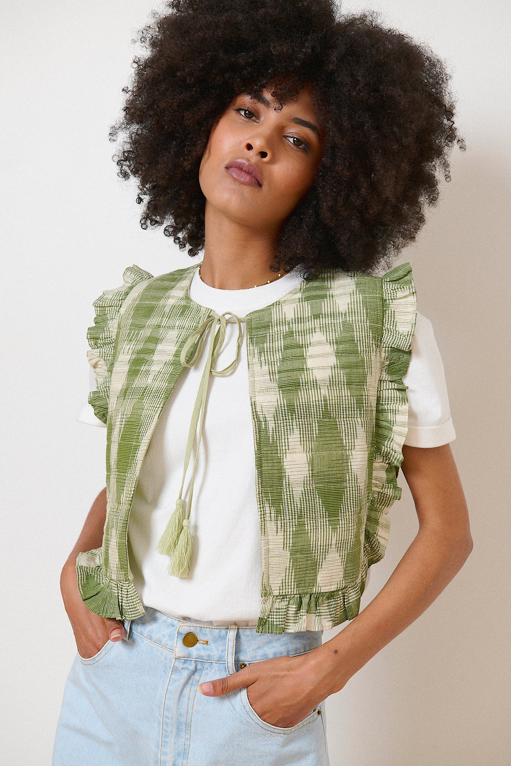 Veste kaki sans manches en tissu ikat, lien à pompons au col et volants pour une touche bohème