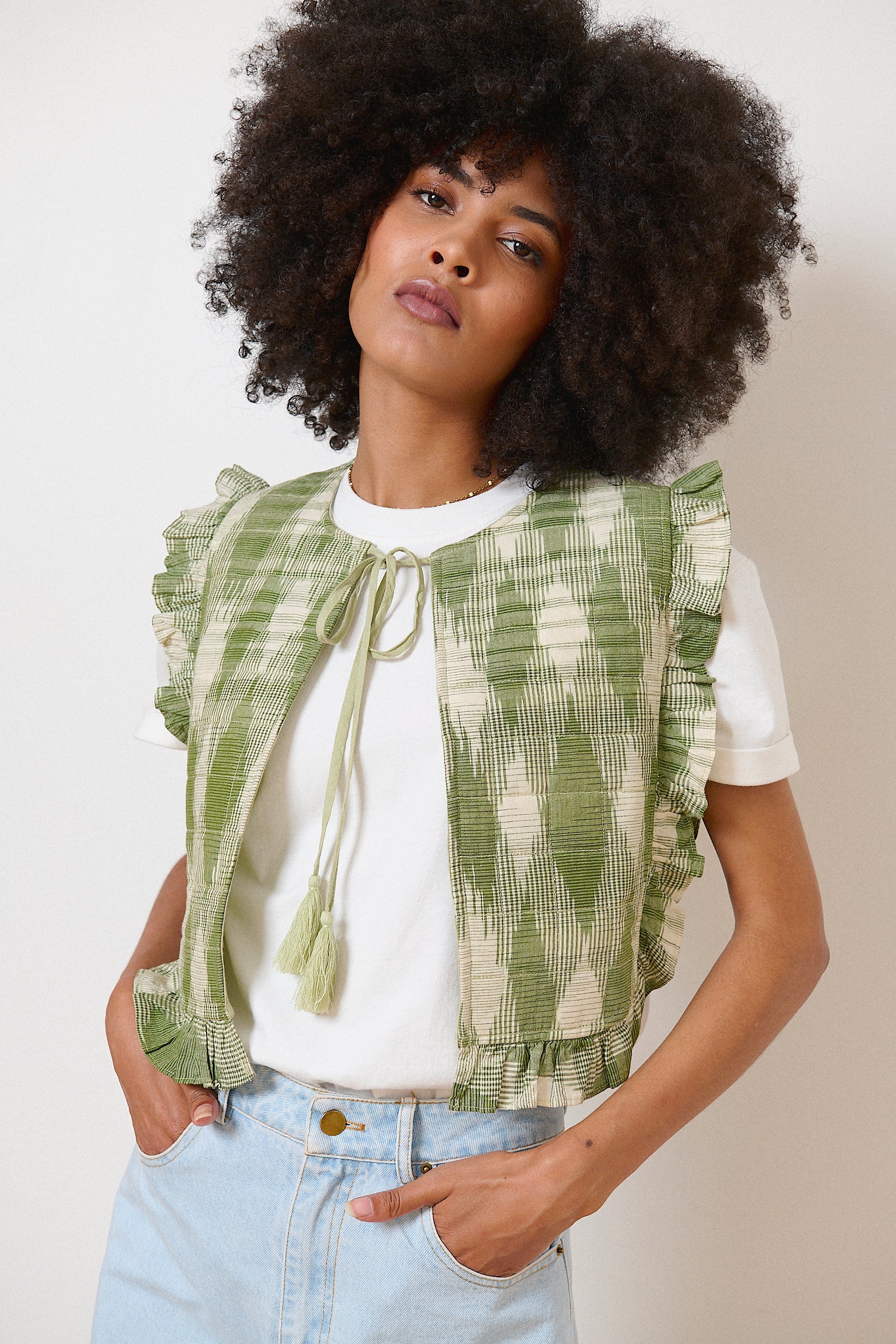 Veste kaki sans manches en tissu ikat, lien à pompons au col et volants pour une touche bohème