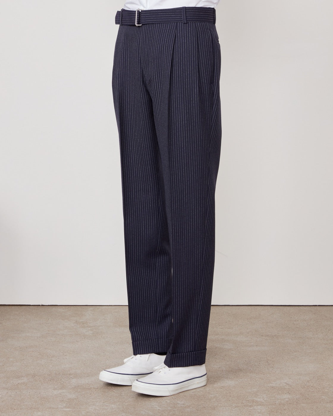Officine Générale – Pantalon Pierre - Bleu Marine/Blanc/Gris - Femme, pantalon bleu marine à fines rayures blanches, porté de profil avec des baskets blanches