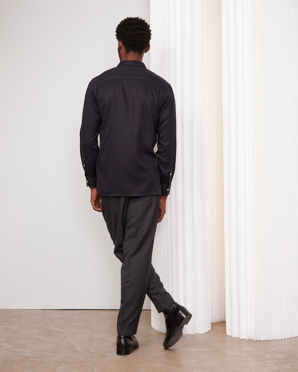 Officine Générale – Chemise Guido - Bleu Marine - Homme, homme de dos portant une chemise noire et un pantalon gris