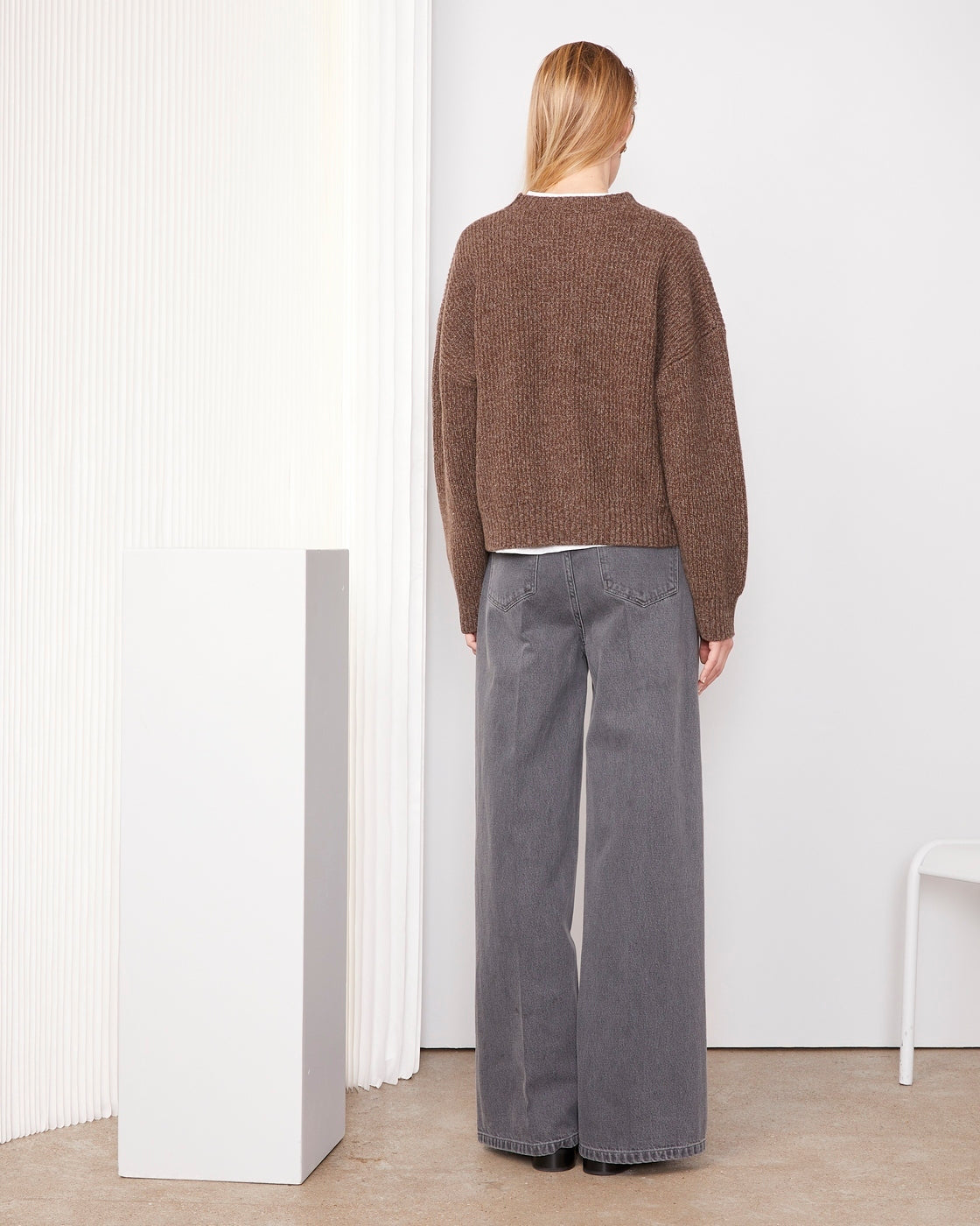 Officine Générale – Pull Mimy Col Rond - Café Glacé/Gris Moyen - Femme, mannequin de dos portant un pull marron et un pantalon gris