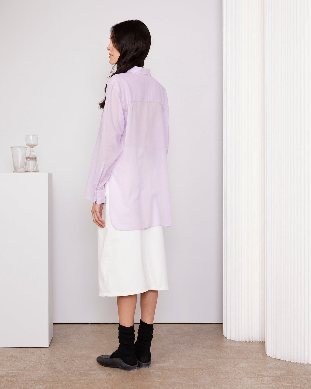 Officine Générale – Chemise Augustine Patte Cachée - Orchidée - Femme, mannequin de dos portant une chemise longue lavande et une jupe blanche