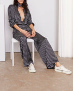 Officine Générale – Chemise Elzi - Bleu Marine/Écru - Femme, mannequin assise de face, portant un ensemble pantalon et chemise noirs et blancs