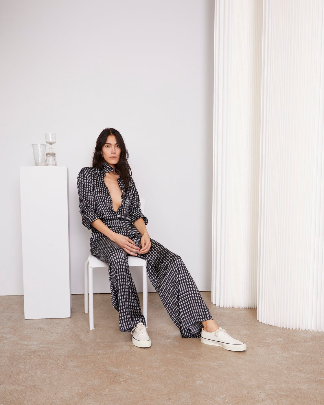 Officine Générale – Chemise Elzi - Bleu Marine/Écru - Femme, mannequin assise de face, portant un ensemble pantalon et chemise noirs et blancs