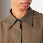 Officine Générale – Chemise Augustine Patte Cachée - Olive Nuit - Femme, mannequin femme portant une chemise kaki et des boucles d'oreilles dorées