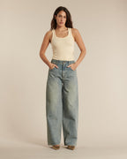 Jean femme en denim bleu délavé, coupe large et droite avec un tombé fluide, conçu en coton pour un confort optimal et un style décontracté.