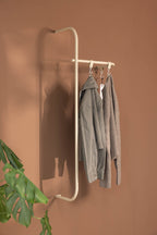 Modern Wardrobe TAMINA with minimalist Metallstangen and Kleidung in einem stylish Raum.