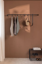 Modern TAMINA Wardrobe with minimalist accessories for clothes and accessories on a wall.
