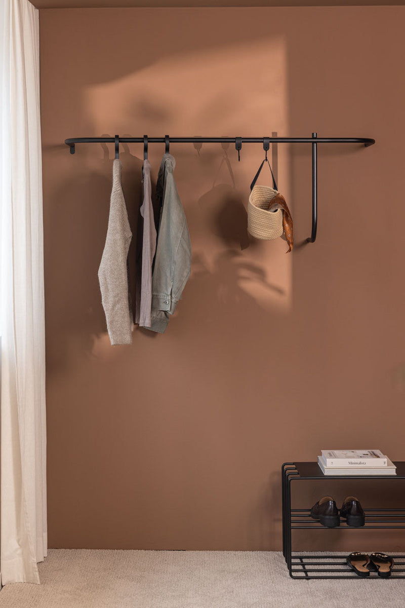 Armario TAMINA moderno con complementos minimalistas para ropa y complementos en una pared.