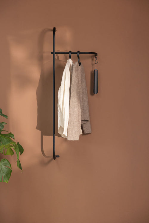 Moderne Garderobe TAMINA aus Metall mit Kleidung an der Wand montiert.