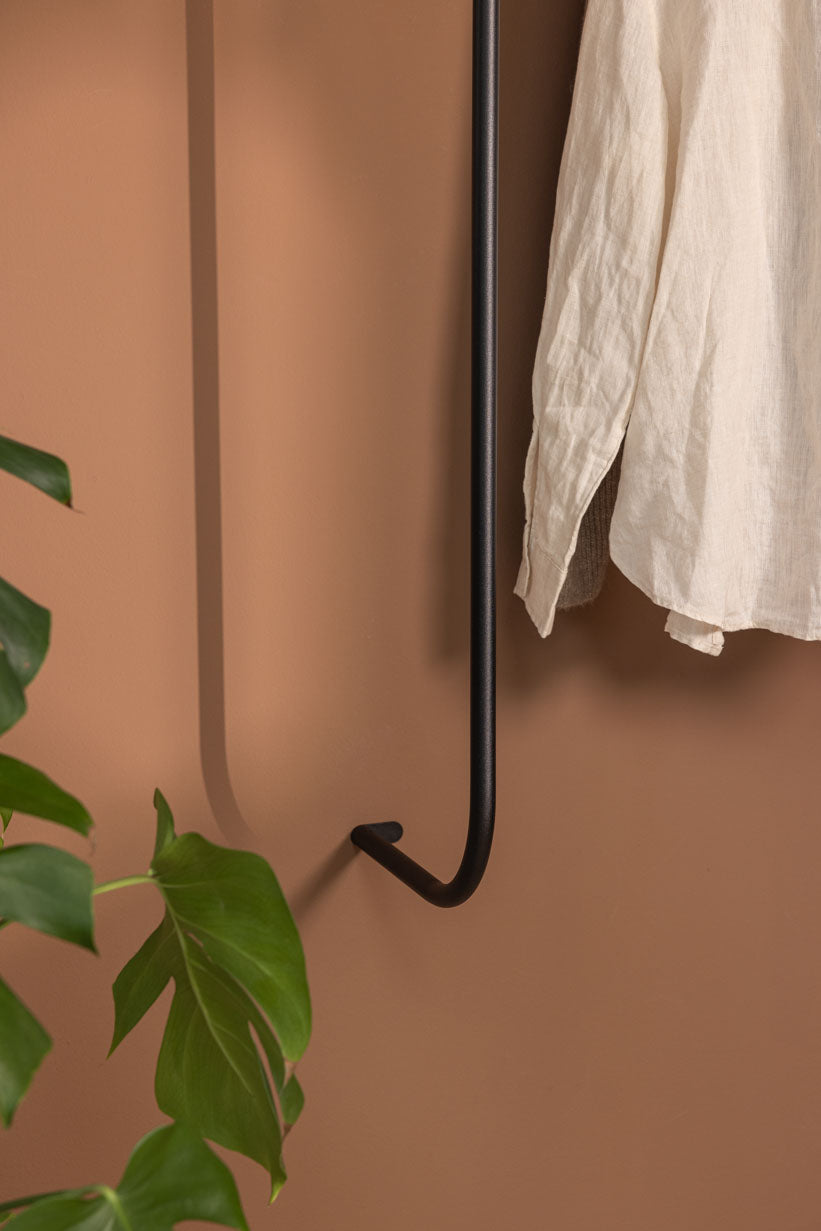 Wardrobe TAMINA with minimalist metal materials and extended handles on one wall-colored wall.