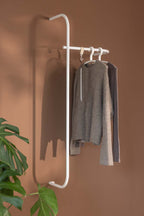 Modern Wardrobe TAMINA with minimalist Metallstangen and aufgehängten Kleidungsstücken.