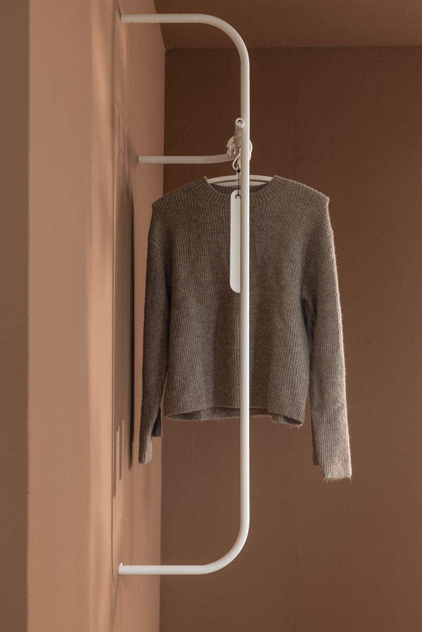 Modern Wardrobe TAMINA with a gray Pullover with a minimalist Kleiderbügel.