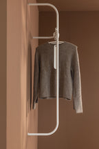 Modern Wardrobe TAMINA with a gray Pullover with a minimalist Kleiderbügel.