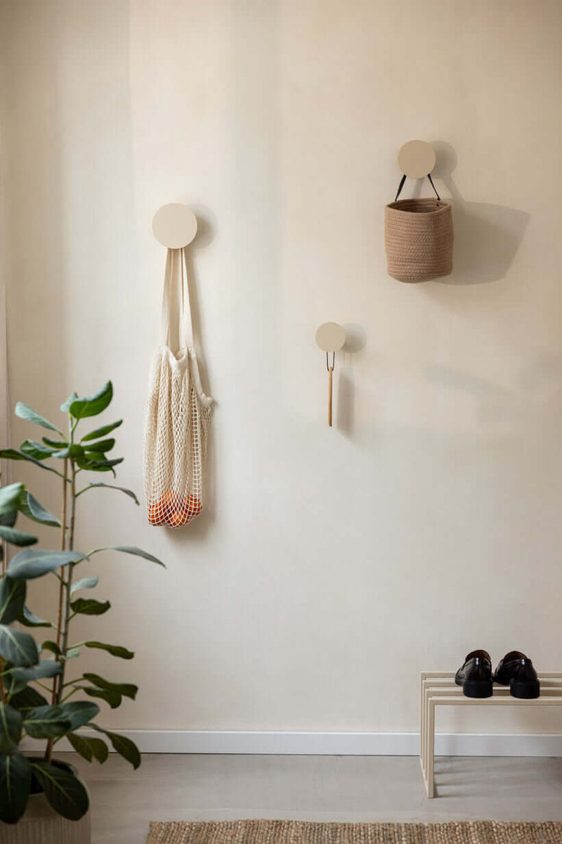 Moderne Wandhaken LOU im minimalistischen Design mit Tasche und Baumwollnetz an einer Wand. Wandhaken für Ordnung.