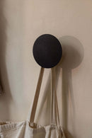 Wandhaken LOU in modernem Design, an der Wand montiert, mit einer Tasche, die daran hängt.