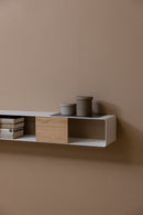 Hängekonsole SION en un diseño minimalista con Holz- und Aufbewahrungsboxen an einer Wand.