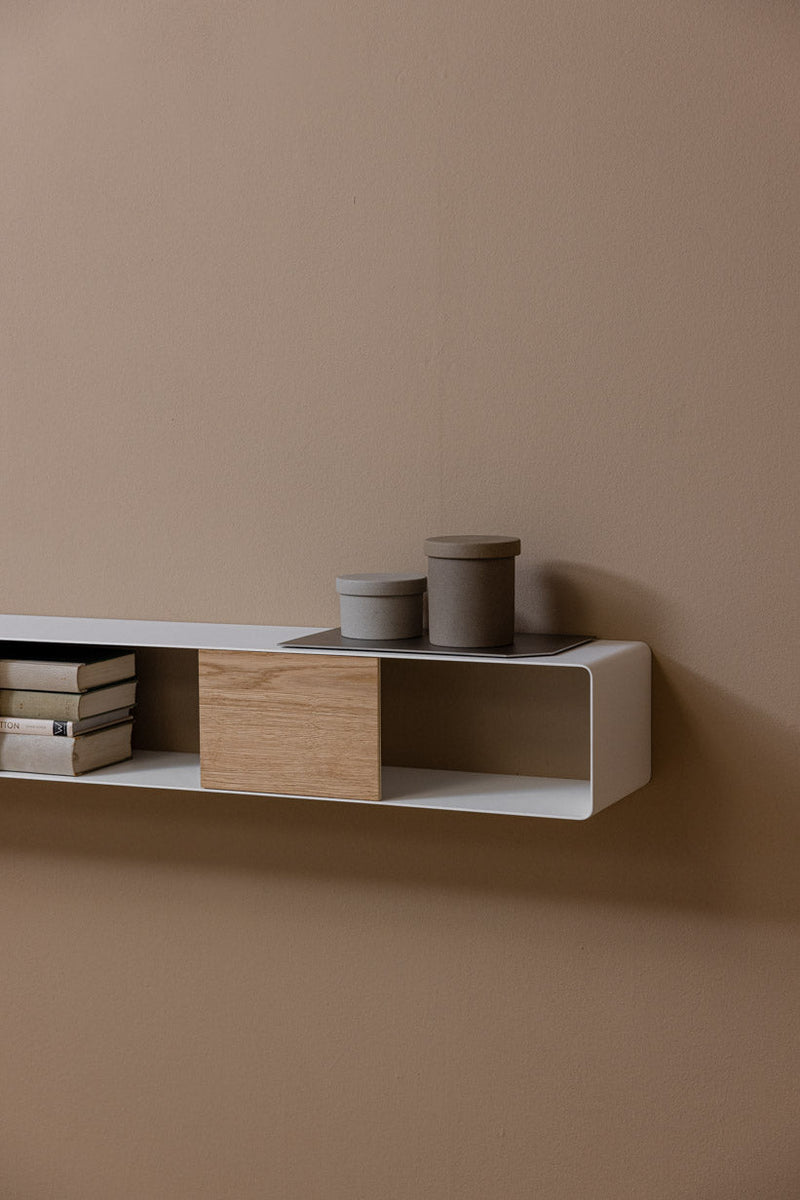 Hängekonsole SION en un diseño minimalista con Holz- und Aufbewahrungsboxen an einer Wand.