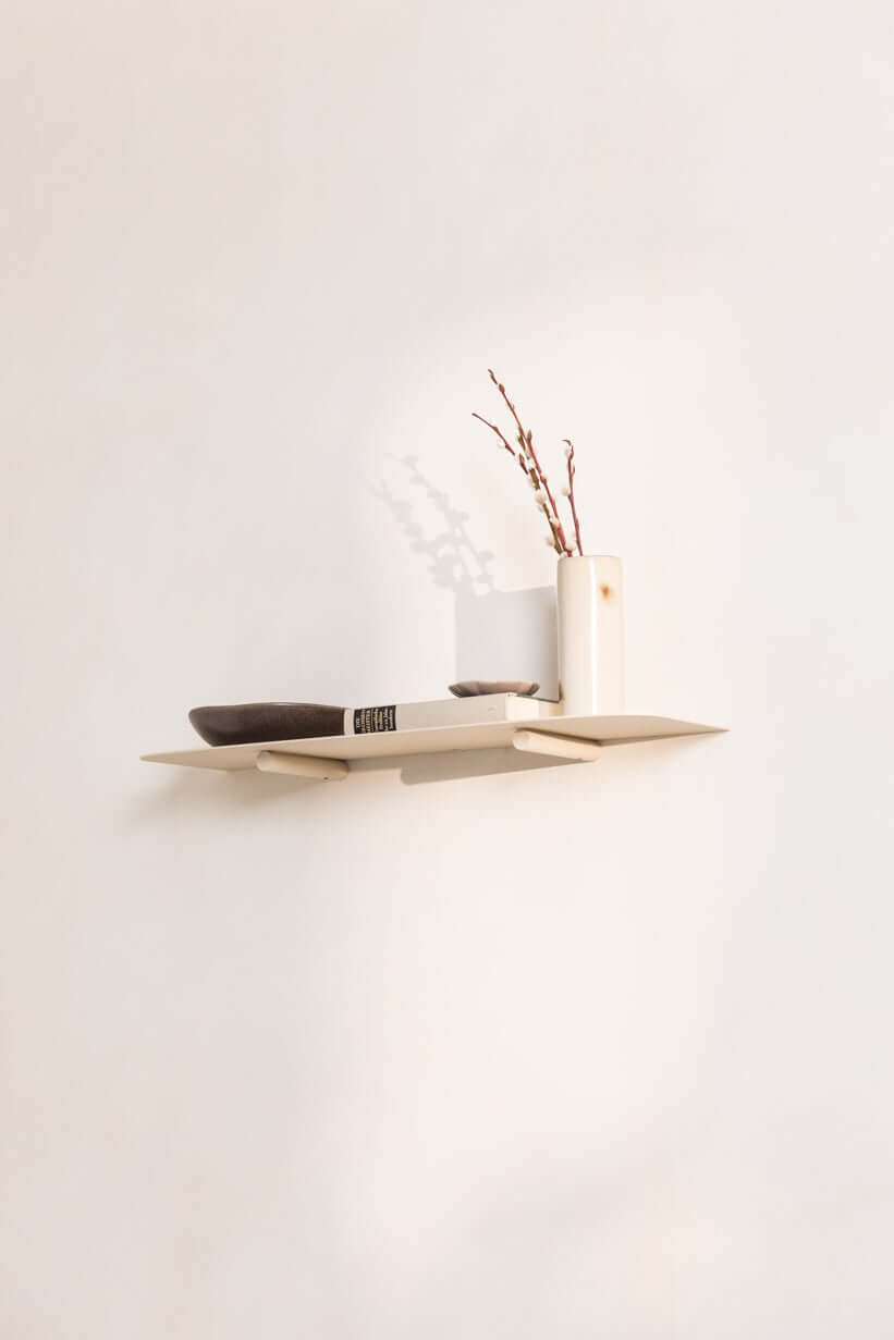 Wandregal LENN aus Metall mit minimalistischer Gestaltung und dekorativem Zubehör.