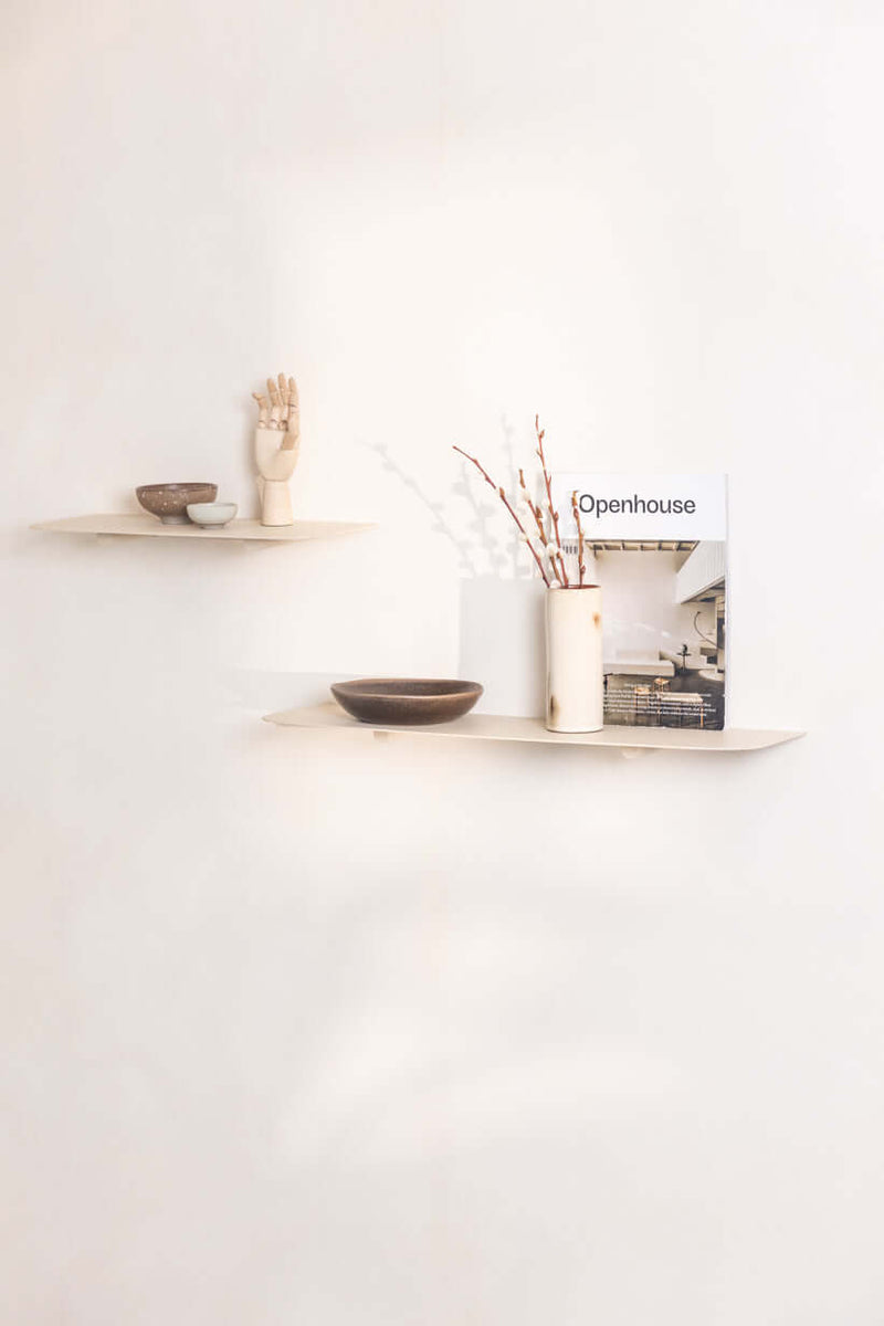 Wandregal LENN mit verschiedenen dekorativen Objekten und Magazin auf weißer Wand.