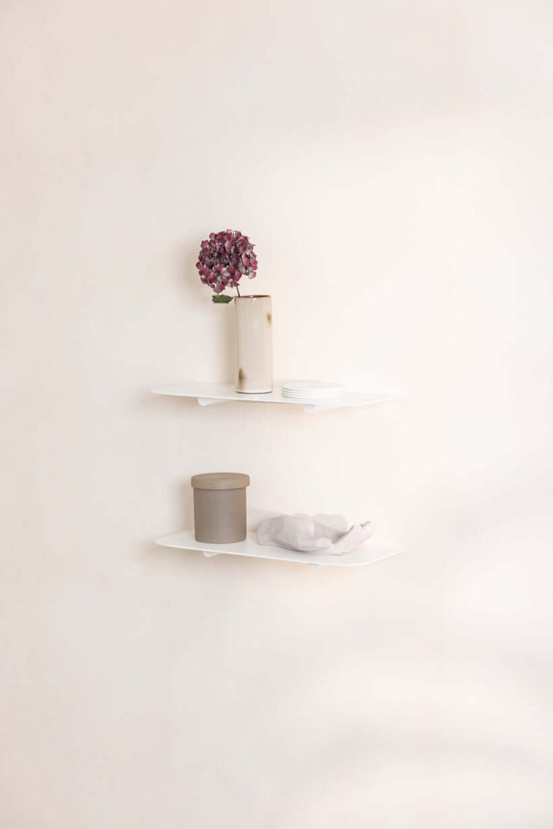 Wandregal LENN mit minimalistischen Regalen und dekorativen Accessoires an einer Wand.