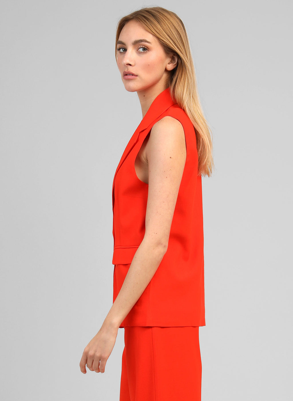 An'ge – Giacca Smanicata Zakarita Piment, modella che indossa un gilet lungo rosso, vista di profilo