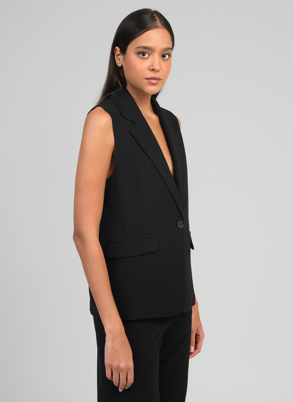 An'ge – Veste Sans Manches Zakarita Noir, mannequin portant un gilet de costume noir, vue de profil