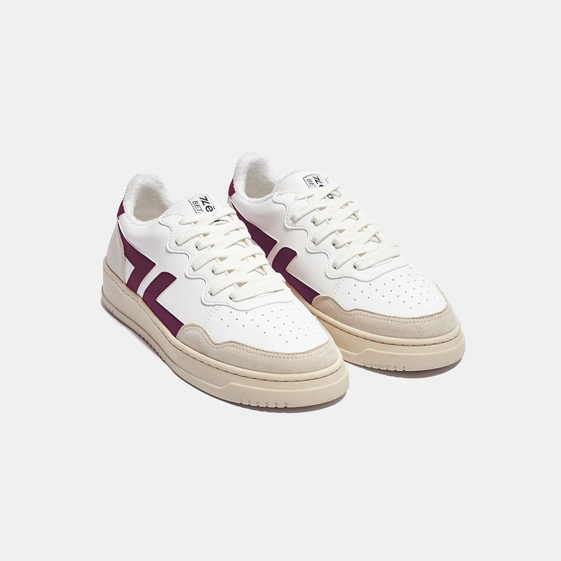 Zapatillas blancas y moradas con suela gruesa. Estas zapatillas son veganas y están hechas de materiales reciclados.