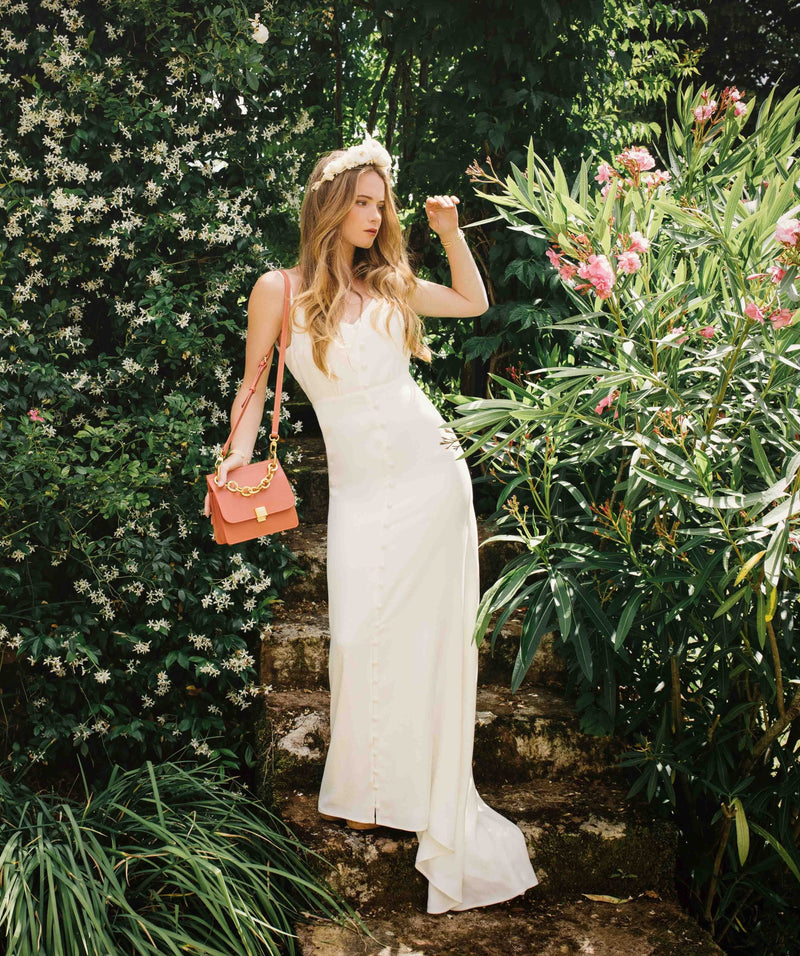 Présentation modèle rose vif Ciel de Vénus, petit sac à main de cuir lisse, haut de gamme presque carré, tenue main par chaîne dorée courte, porté à l'épaule via lanière cuir amovible et ajustable. Made in Italy, Pö&Me Paris