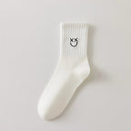 Chaussettes blanches montantes avec smiley, confortables et stylées, idéales avec des baskets. Coton épais, look tendance et maintien optimal.