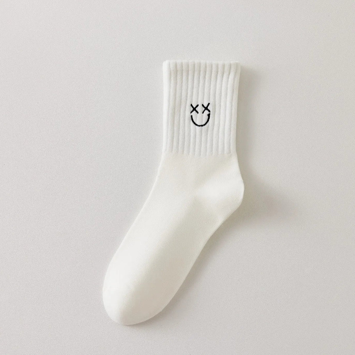 Chaussettes blanches montantes avec smiley, confortables et stylées, idéales avec des baskets. Coton épais, look tendance et maintien optimal.