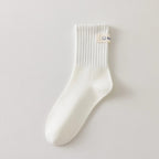 Chaussettes blanches montantes avec smiley, confortables et stylées, idéales avec des baskets. Coton épais, look tendance et maintien optimal.