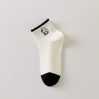 Chaussette femme noir et blanc vendue à l’unité, brodée d’un motif chien graphique. Taille 35-41. Confortable, douce et originale pour un look casual chic.