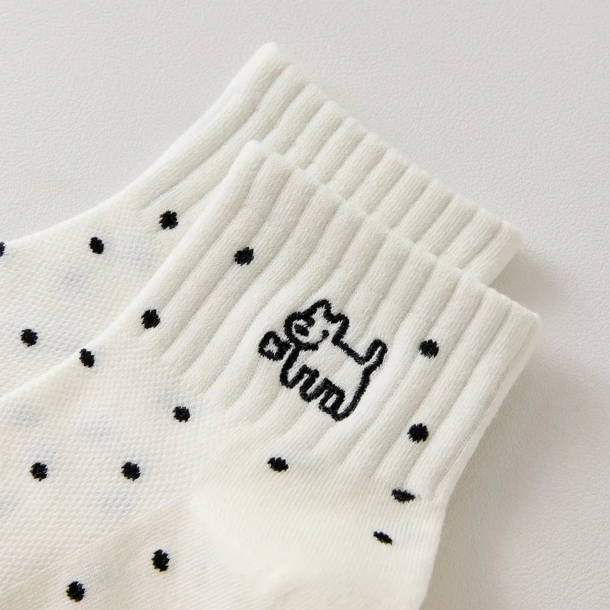 Chaussette femme noir et blanc vendue à l’unité, brodée d’un motif chien graphique. Taille 35-41. Confortable, douce et originale pour un look casual chic.