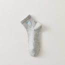 Lot de 3 chaussettes mi-hautes femme avec cœur bleu brodé. Coloris doux : gris, blanc cassé, bleu ciel. Bord côtelé. Confort et style au quotidien.
