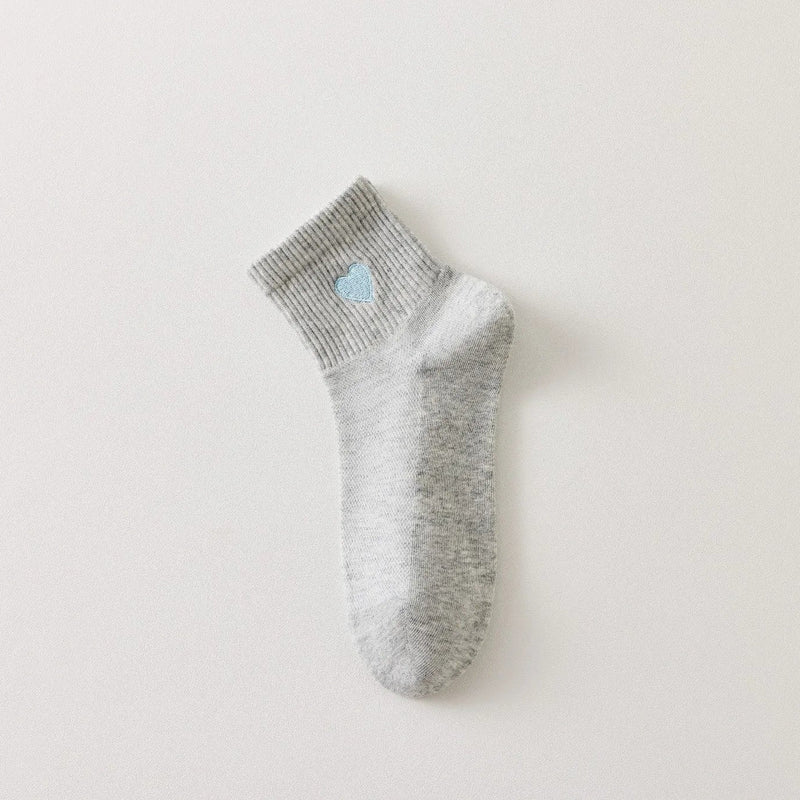 Chaussettes femme mi-hautes avec cœur brodé bleu. Coloris doux : gris clair ou blanc cassé. Bord côtelé confortable. Taille unique 35-41.

