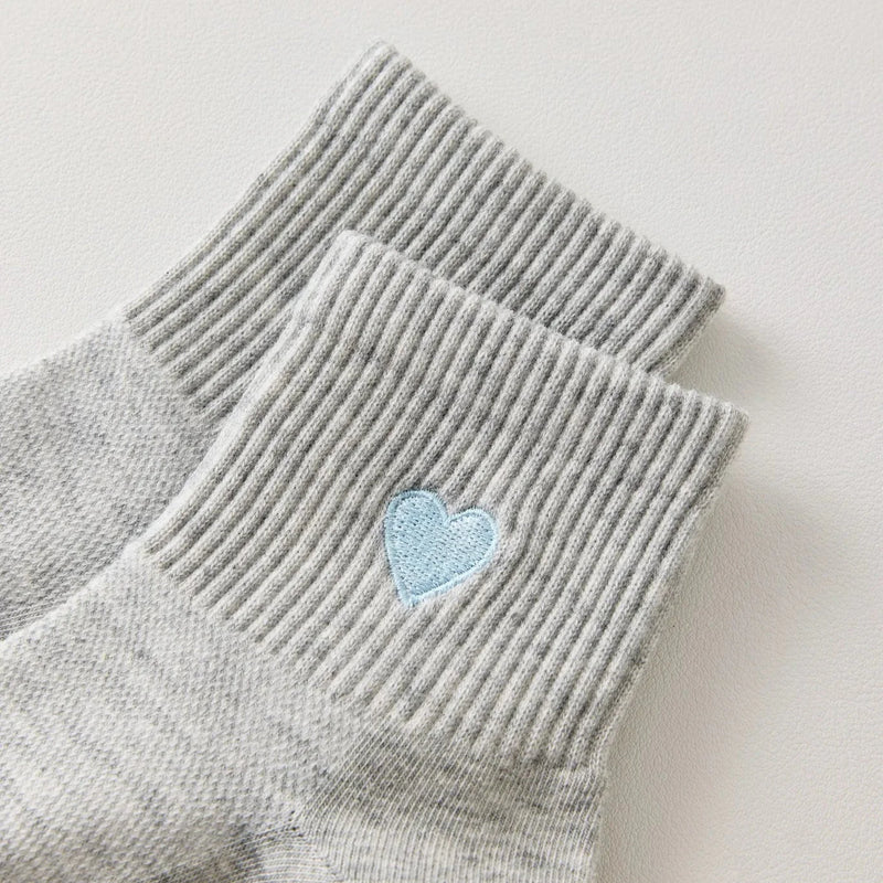 Chaussettes femme mi-hautes avec cœur brodé bleu. Coloris doux : gris clair ou blanc cassé. Bord côtelé confortable. Taille unique 35-41.

