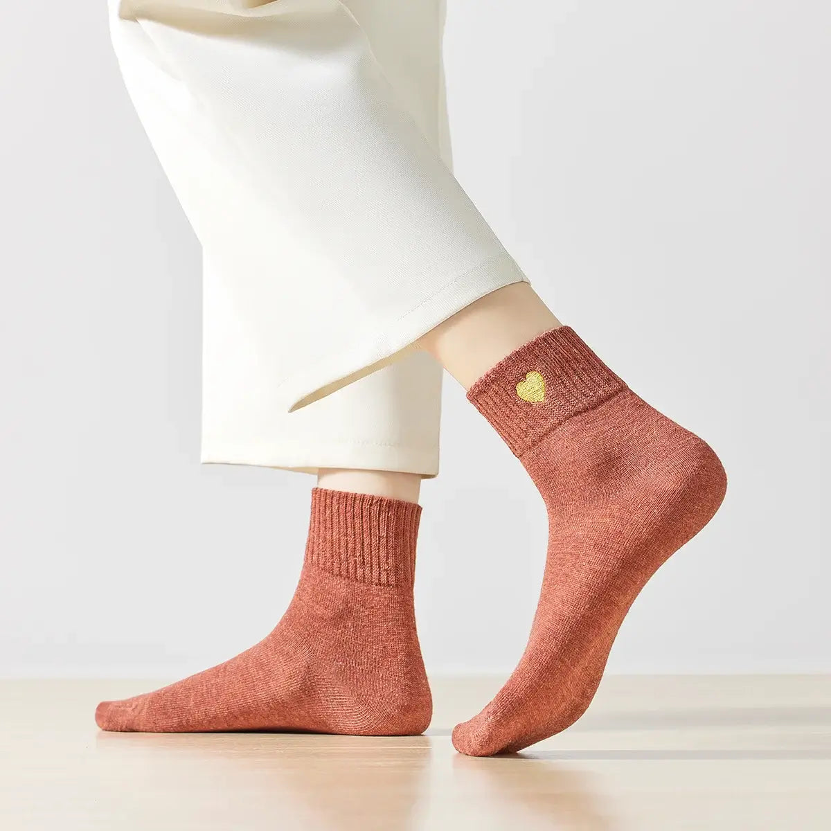 Chaussette haute chaude avec cœur doré brodé.