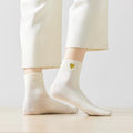 Chaussette haute chaude avec cœur doré brodé.