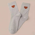 Chaussettes montantes femme, fond beige lurex ou gris chiné, motif coeur et léopard. 