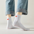 Chaussette haute unie avec cœur rouge brodé au talon.