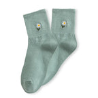 Chaussette haute unie avec marguerite brodée.