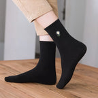 Chaussette haute unie avec marguerite brodée.