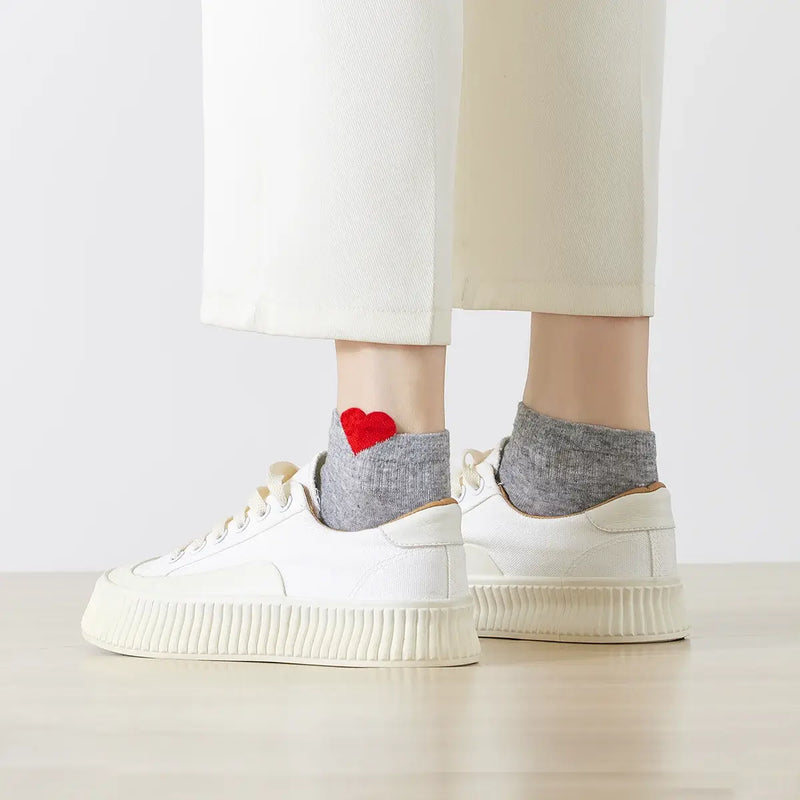 Chaussette unie avec petit cœur rouge brodé.